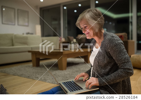 Senior woman sitting on the floor working on Senior woman sitting on the floor working on 28526184