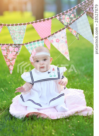 little girl in white dress sitting on the grass in little girl in white dress sitting on the grass in 28527879
