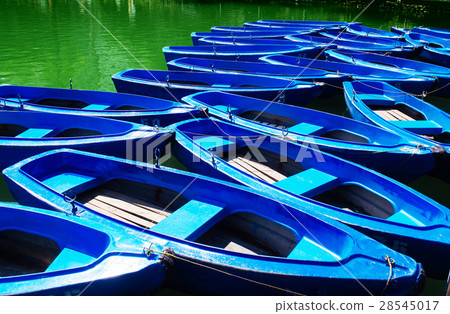 Many blue wooden boat transport with green lake outdoor scenery 28545017