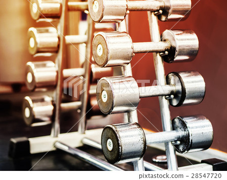 Stand with dumbbells in gym 28547720