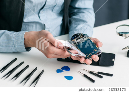 Disassembled smartphone on repairman workplace Disassembled smartphone on repairman workplace 28552173
