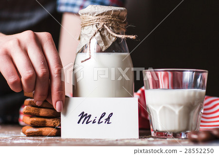 Woman holding card near bottle of milk 28552250