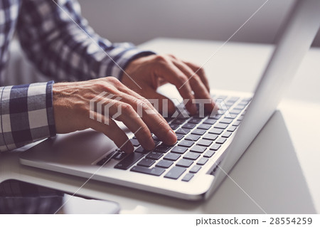 Man working on a laptop in office 28554259