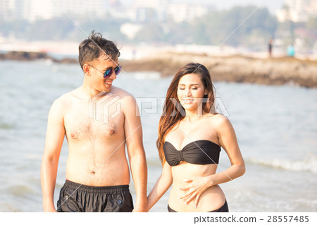 Happy asian man and women lover posing on the beac 28557485