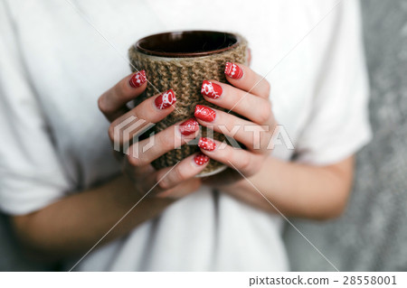 Young woman holding decorative cup 28558001