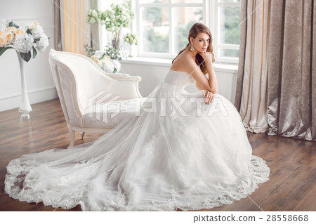Bride in beautiful dress sitting resting on sofa Bride in beautiful dress sitting resting on sofa 28558668