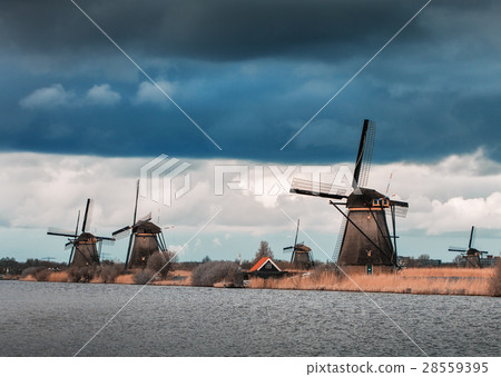 Windmills against cloudy sky at sunset Windmills against cloudy sky at sunset 28559395