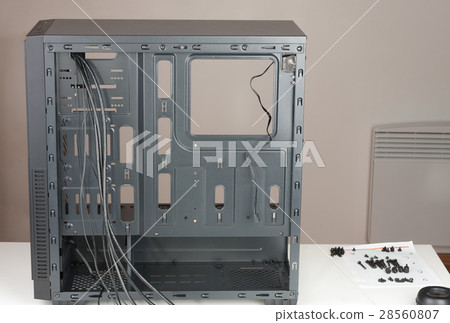Empty black computer chassis  with screws on table. 28560807