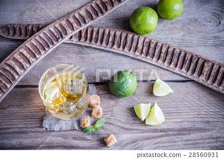 Glass of rum on the wooden background Glass of rum on the wooden background 28560931