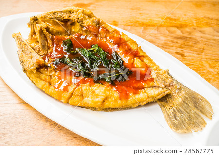 Fried sea bass fish in white plate with spicy and sweet sauce 28567775