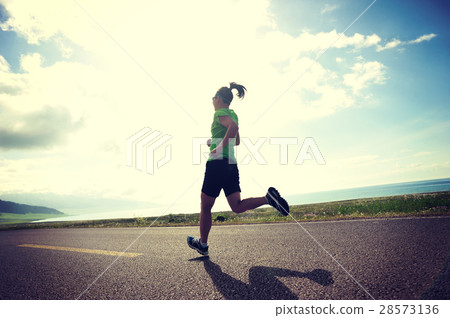 woman trail runner running on country road 28573136