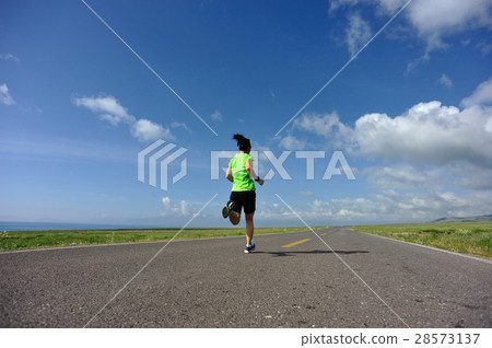 woman trail runner running on country road 28573137