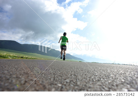 woman trail runner running on country road woman trail runner running on country road 28573142