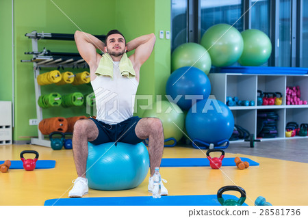 Male athlete kneeling down by dumbbells toweling 28581736