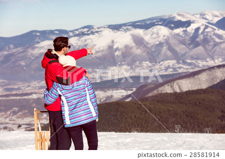Rear view of a loving couple in fur hood jackets Rear view of a loving couple in fur hood jackets 28581914
