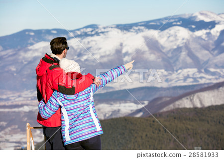 Rear view of a loving couple in fur hood jackets 28581933