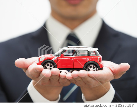 A young businessman with a red mini car A young businessman with a red mini car 28583197