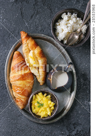 Breakfast with croissant and mango fruit 28583968
