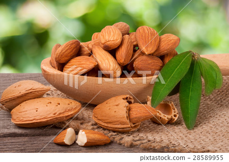 heap of peeled almonds with leaf in a wooden spoon heap of peeled almonds with leaf in a wooden spoon 28589955