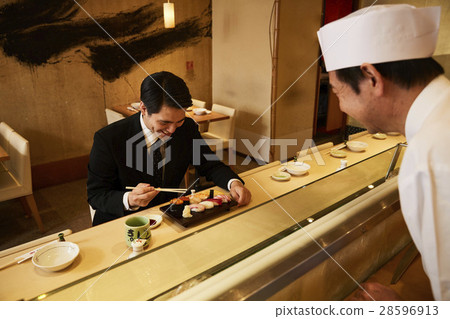  A businessman who eats sushi 28596913