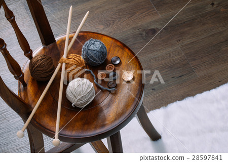 button and yarn ball on wooden chair 28597841