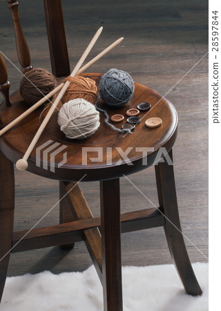 button and yarn ball on wooden chair 28597844
