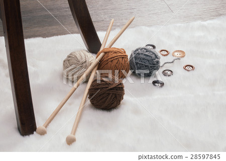 button and woolen yarn ball on carpet 28597845