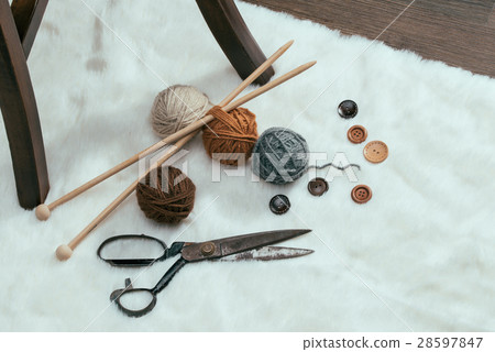 button, scissors and yarn ball on carpet 28597847