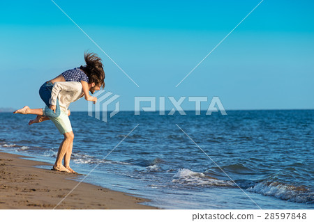 Handsome man giving piggy back to his girlfriend 28597848