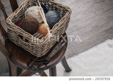 scissors and yarn inside old basket wooden chair 28597856