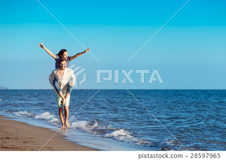 Handsome man giving piggy back to his girlfriend 28597965