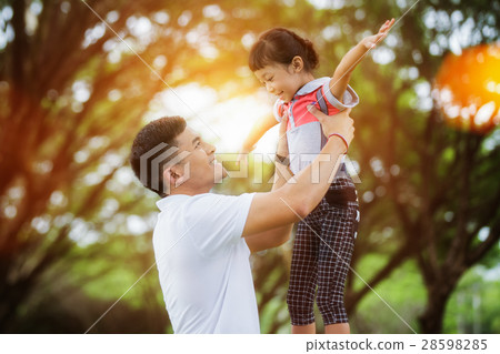 Portrait of little girl hugging her daddy with nature and sunlig Portrait of little girl hugging her daddy with nature and sunlig 28598285