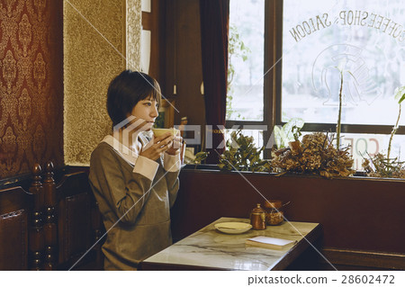 A woman relaxing at a coffee shop 28602472