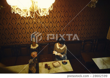 A woman relaxing at a coffee shop 28602599