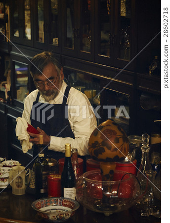 Shop owner wiping dishes 28602718