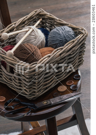 scissors and yarn inside old basket wooden chair 28603461