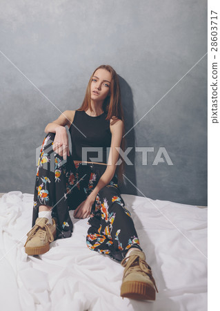 Fashion girl sitting on floor against white wall 28603717