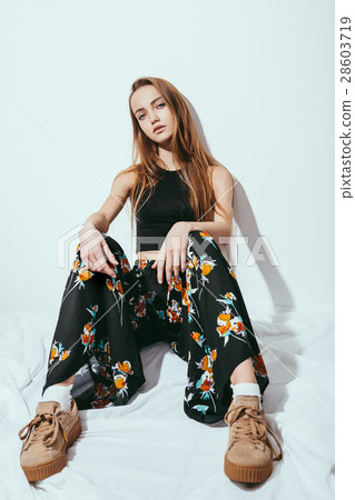 Fashion girl sitting on floor against white wall 28603719