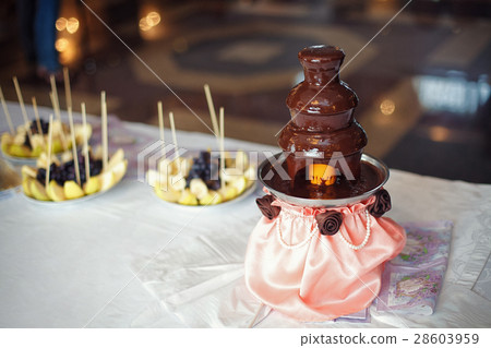 Chocolate fondue fountain with prepared fruits 28603959