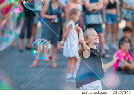 Adorable little girl blowing soap bubbles in Adorable little girl blowing soap bubbles in 28607545