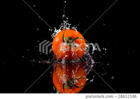 The tomato with drops stands on the black The tomato with drops stands on the black 28612106