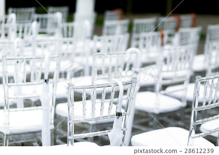 Look from behind at white plastic chairs  28612239