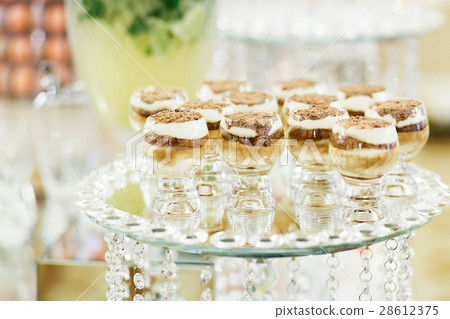 Tiramisu served in whisky glasses stands  28612375