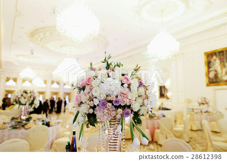 Tall vase with bouquet of tiny roses stands  28612398