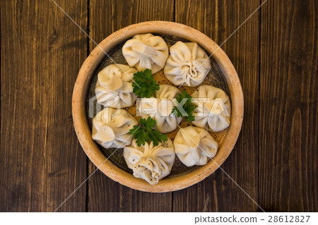 Khinkali on a plate on a wooden table. Traditional 28612827