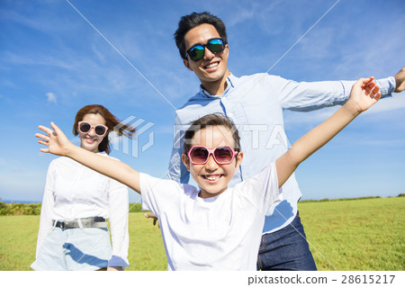 Happy young family playing on the grass Happy young family playing on the grass 28615217
