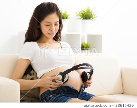 Pregnant Woman Holding Headphones On Her Belly Music For Baby Concept  Pregnancy And Music Stock Photo - Download Image Now - iStock