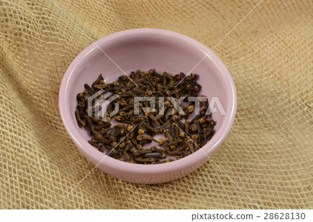 Whole cloves spice in pink dish on burlap 28628130