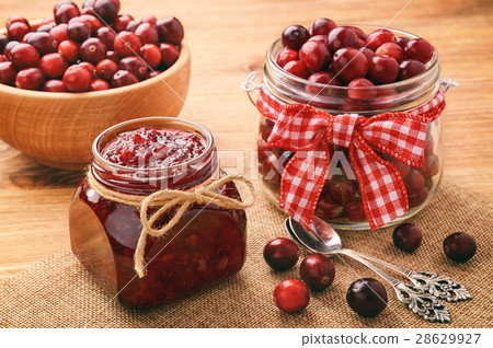 圖庫照片: cranberry jam on brown wooden background.