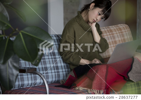A woman operating a personal computer in a room A woman operating a personal computer in a room 28637277